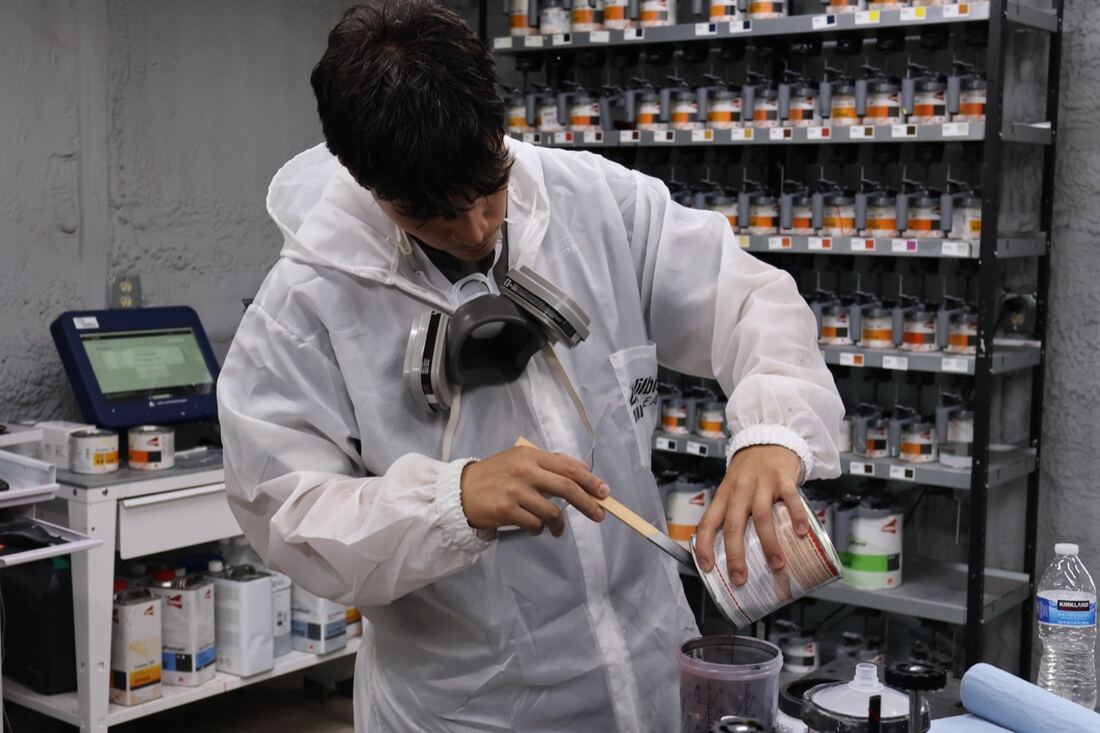 An Apex technician mixing factory-match paint in the mixing room